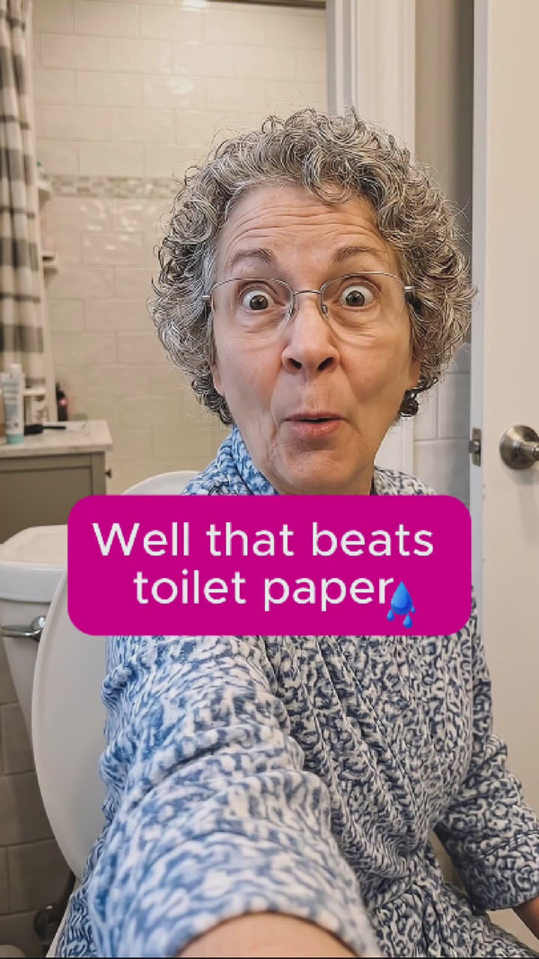 Older granny looking woman with the most endearing smile and gray short, curly hair in selfie reaction video during her first cleaning with her new Hey Hey Bidet. She is positively flabbergasted.