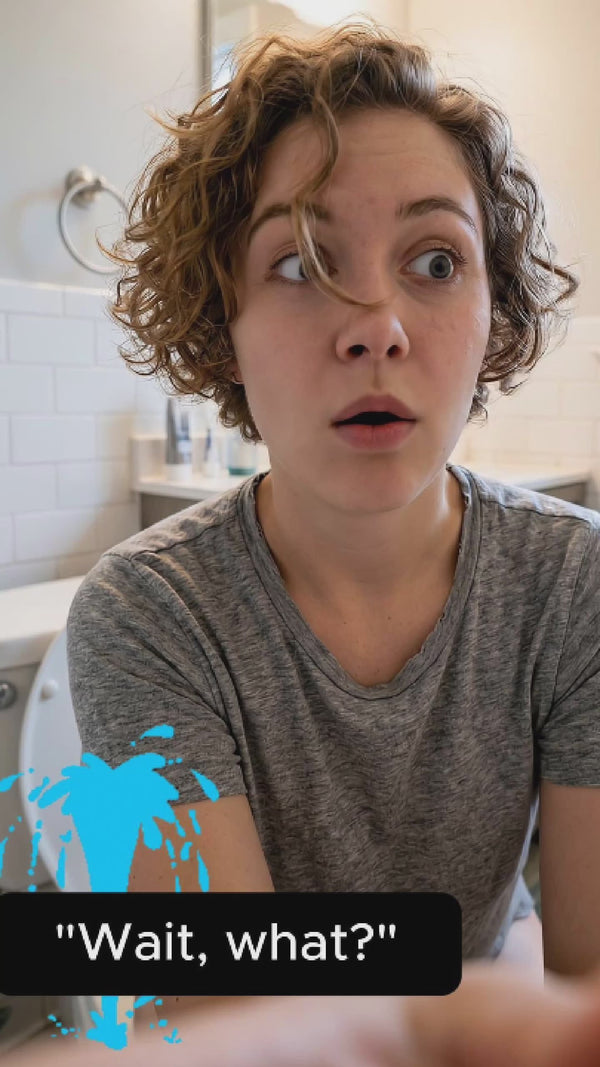 Young woman with short, curly red hair in selfie reaction video during her first cleaning with her new Hey Hey Bidet. She's delighted.